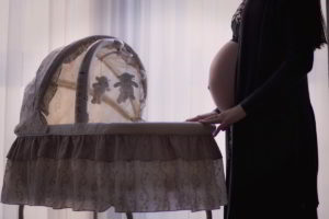 Zdjęcia z kobietą w ciąży i łóżeczkiem dla dzidziusia