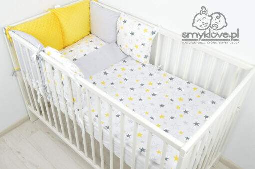 Pościel w żółte i szare gwiazdki w łóżeczku niemowlęcym